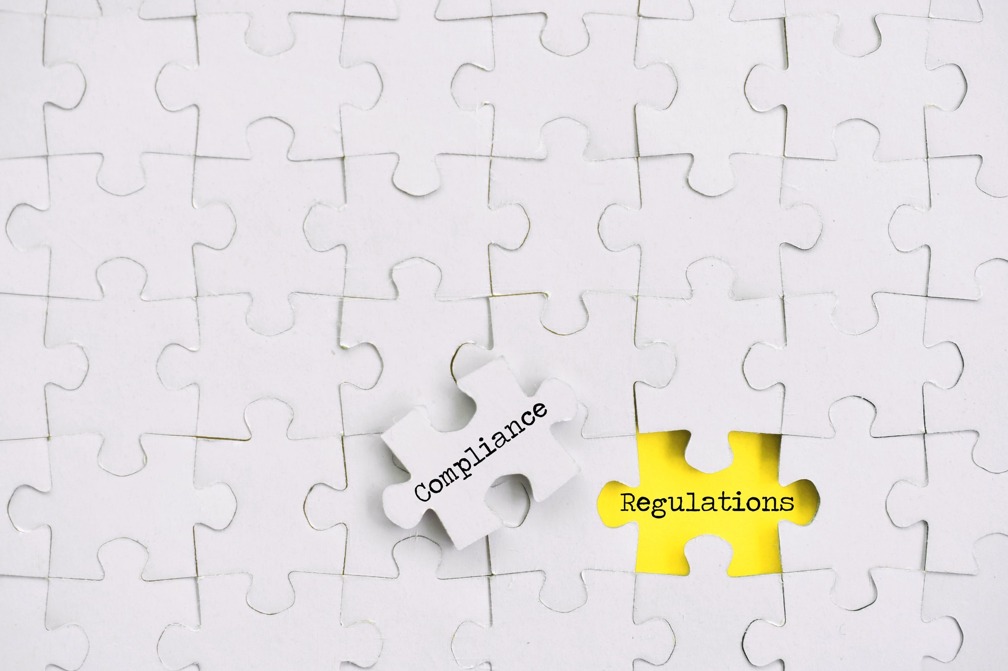 Puzzle pieces Compliance concept - changing procedures to adhere to regulations, yellow